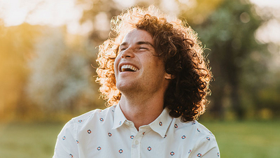 Mann lächelt fröhlich beim Spaziergang