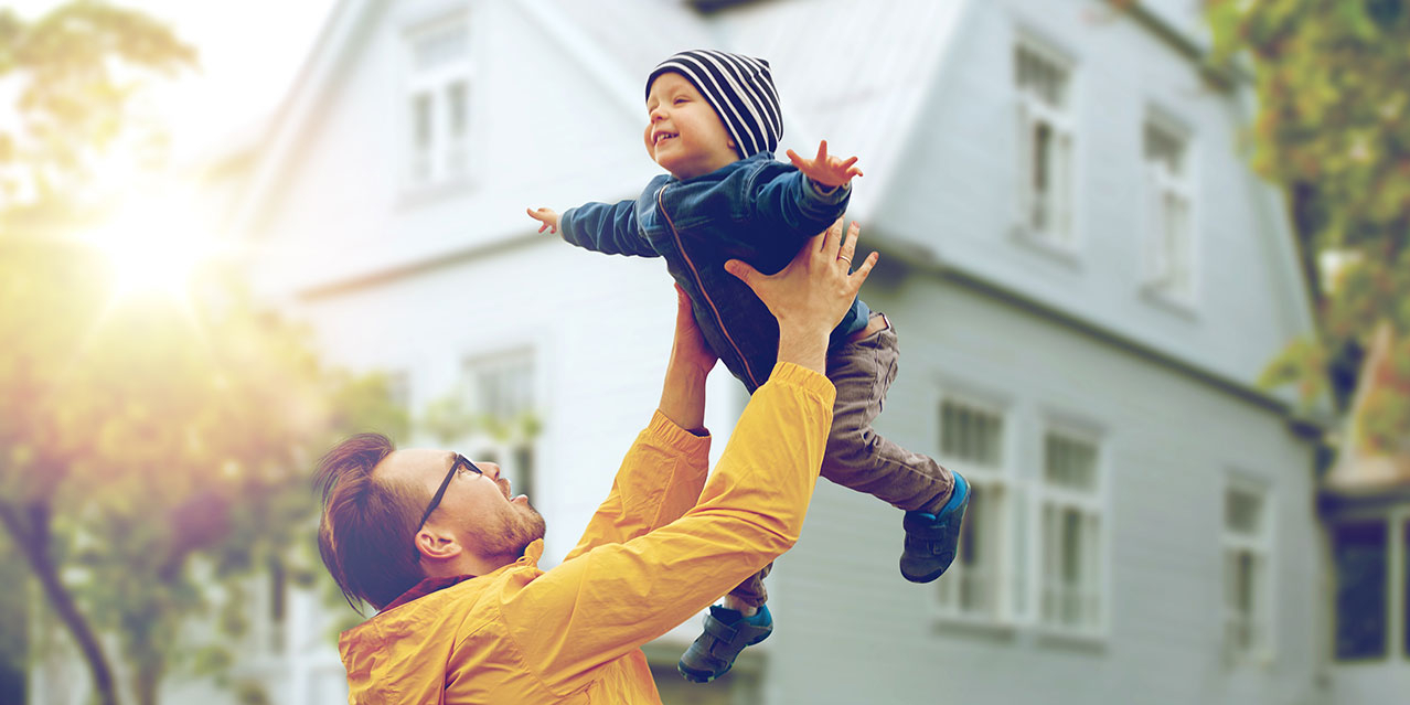 Vater der mit seinem Sohn vor seinem Haus spielt