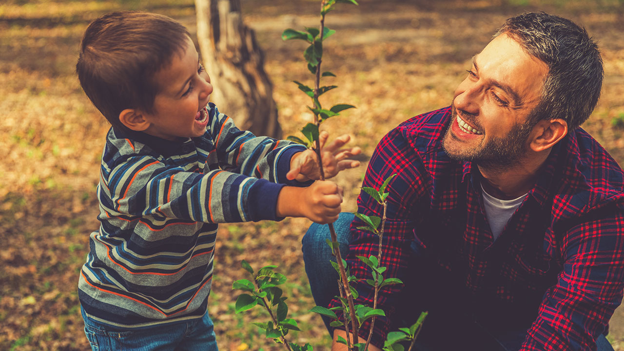 Nachhaltige Geldanlage für den Vermögensaufbau Vater und Sohn spielen gemeinsam draußen