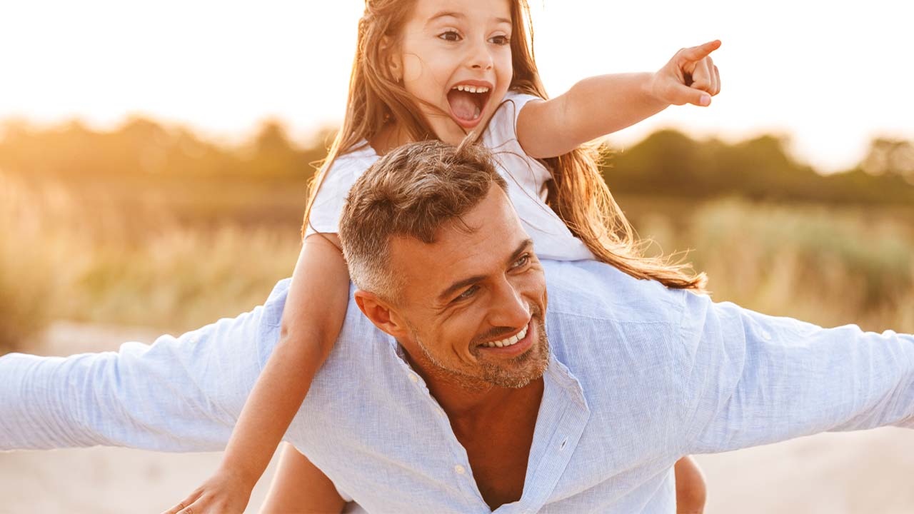 Vater und Tochter freudig am Strand