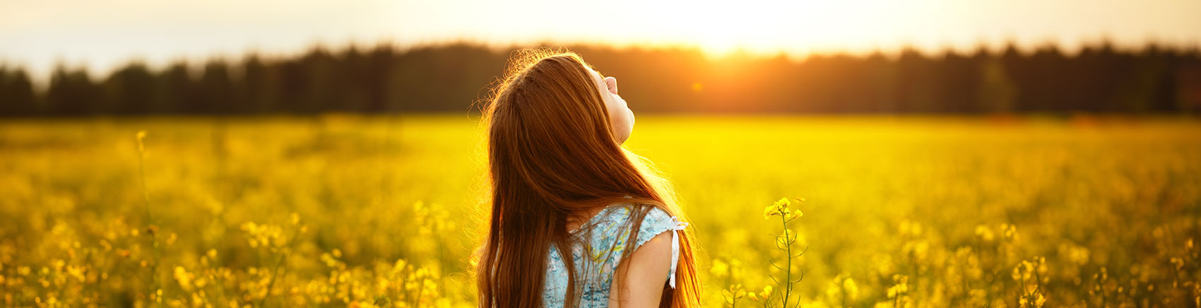 Junge Frau genießt den Sonnenschein auf einer Wiese